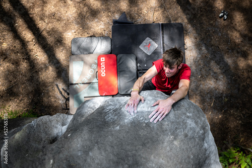 Athletic young man is jumping for top hold in famous and hard dyno boulder problem called 