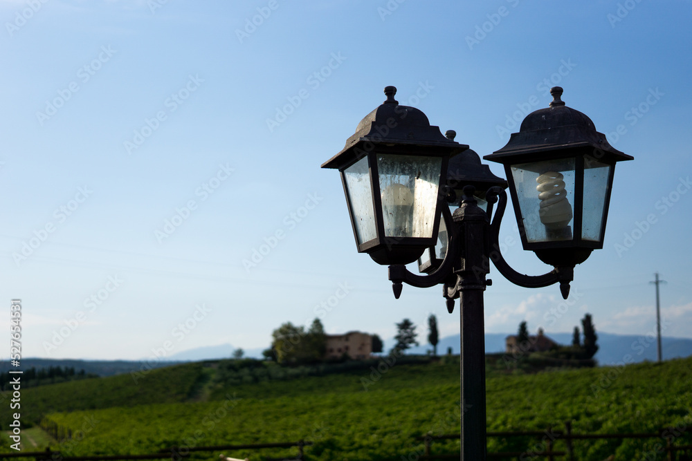 Photograph of a vintage lamppost with cloudy background and blue sky.