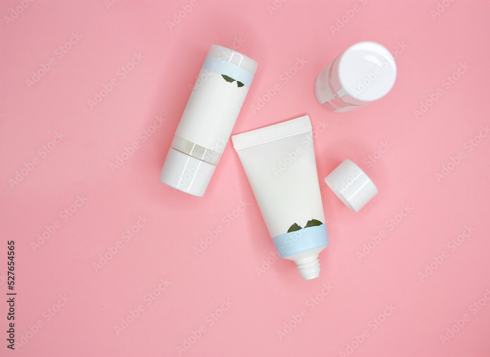Flat lay with blank cosmetic products lotion, cleanser, tonic, essence, cream on pink background. Top view. Hygiene bottles. Dermatology, cosmetology. Beauty concept mock up. Selective focus. Flat lay with blank cosmetic products lotion, cleanser, tonic, essence, cream on pink background. Top view. Hygiene bottles. Dermatology, cosmetology. Beauty concept mock up. Selective focus.