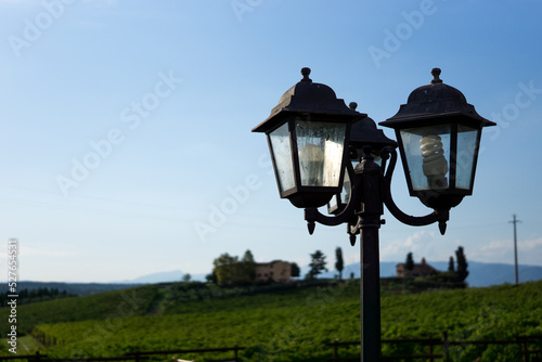 Photograph of a vintage lamppost with cloudy background and blue sky.