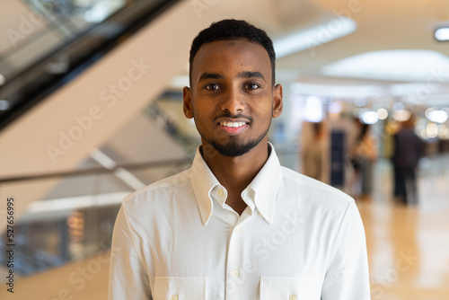 Portrait of young handsome stylish black man in city