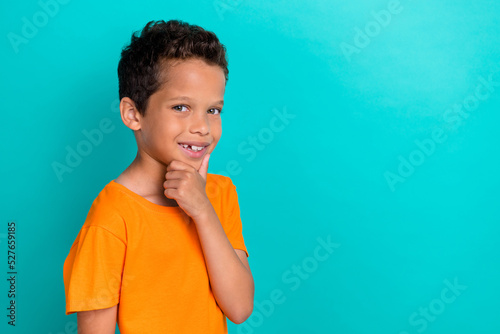 Photo of funky smart small man wear yellow t-shirt arm chin empty space isolated turquoise color background