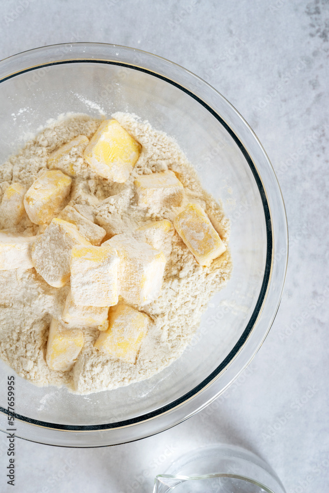 Foto de cubes cold butter in a glass bowl with all-purpose flour in ...