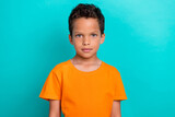 Photo of charming pretty small man wear orange t-shirt smiling isolated turquoise color background