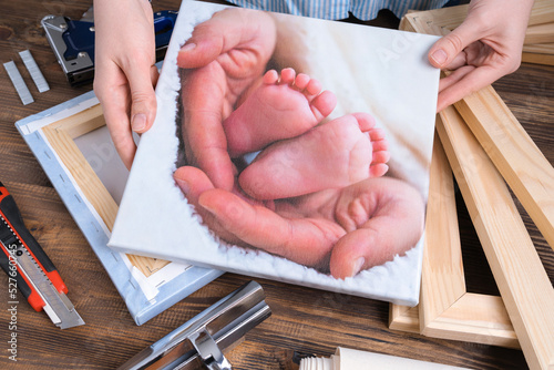The master demonstrates a photo of children's legs printed on canvas and stretched on a stretcher.