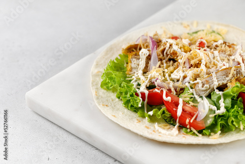 Tortillas, Flatbread with chicken meat, lettuce, tomatoes, cheese, sauce. Easy to cook sandwich.