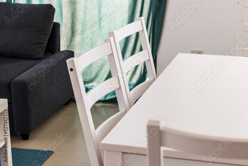 Close up shot of white colored chairs and table. Interior