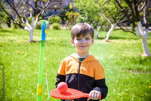 Happy boy is playing tetherball swing ball game in summer campin photo