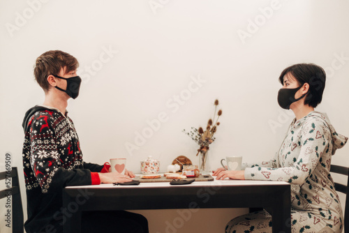 Girl and Guy Have Breakfast at Home in Masks