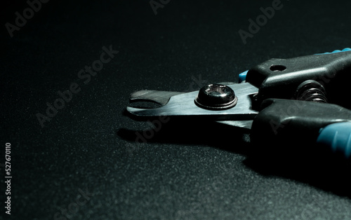 close up pet nail clipper on a black background © Oleg