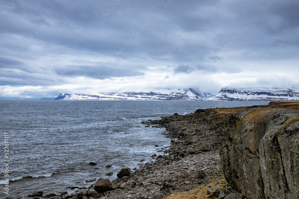 Obraz premium Wolkenstimmung über schneebedeckten bergen und dem Meer