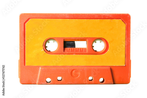 An old vintage cassette tape from the 1980s (obsolete music technology). Vivid colors: coral red plastic body, orange paper label. Isolated.

