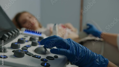 Close-up of the doctor's hand on the ultrasound machine during the examination of the patient