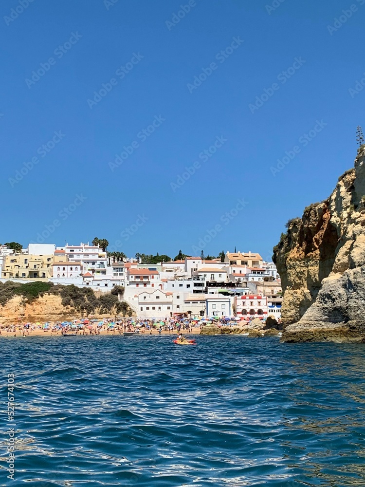 A view of beautiful sandy beach in Armacao de Pera seaside town, Algarve region, Portugal. View from a boat.