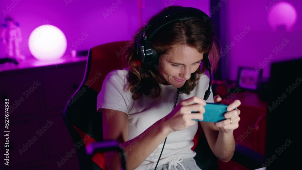 Young beautiful hispanic woman streamer playing video game using smartphone at gaming room Young beautiful hispanic woman streamer playing video game using smartphone at gaming room