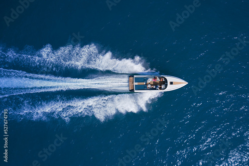 Wallpaper Mural White speedboat fast movement on blue water top view. White large open boat with people moving fast on blue water top view. Torontodigital.ca