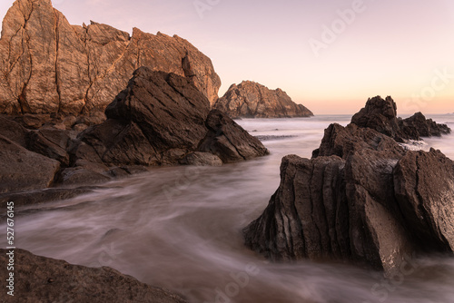 Beautiful long exposure scene of waves reaching the spectacular rock formations on the shore of La Arnía beach, Costa Quebrada, Liencres, Cantabria, Spain