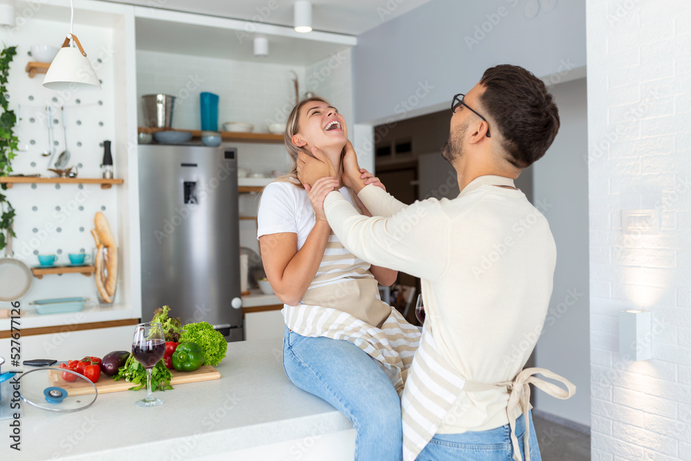 Romantic young couple cooking together in the kitchen,having a great time together. Man and woman laughing in the morning with breakfast Romantic young couple cooking together in the kitchen,having a great time together. Man and woman laughing in the morning with breakfast