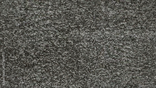 Static noise from an old analog tv screen. Real footage, big grainy random black and white dots.
