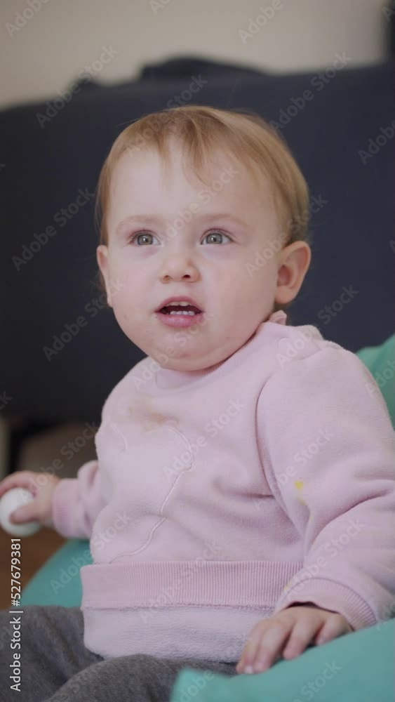 Vertical video of a Cute baby girl playing at home and smiling to the camera Vertical video of a Cute baby girl playing at home and smiling to the camera
