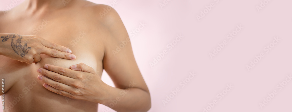 Banner de mujer latina desnuda sobre fondo rosa realizando una autoexploración de su seno para detectar anomalías como prevención del cáncer de mama. Banner de mujer latina desnuda sobre fondo rosa realizando una autoexploración de su seno para detectar anomalías como prevención del cáncer de mama.