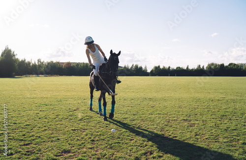 Unrecognizable female jockey riding horse