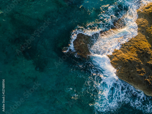aerial view of waves crashing onto rocks © ishootforthegram