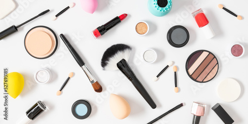 Flat lay, top view of makeup products scattered on white background. Beauty background with facial cosmetic products. 