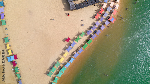 Aerial view of Caraiva beach, Porto Seguro, Bahia, Brazil. Colorful beach tents, sea and river