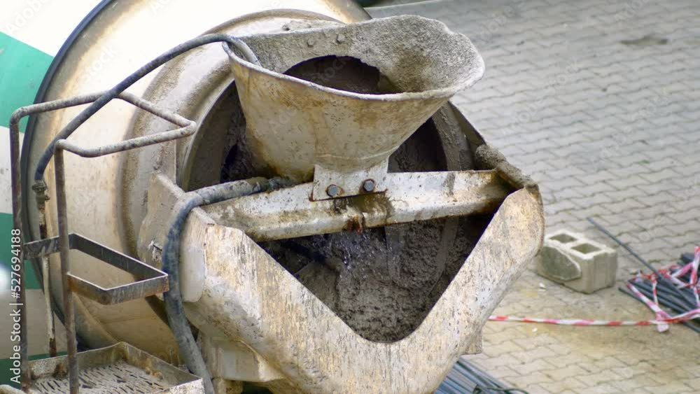 Adding water and mixing concrete in concrete truck. Closeup. Concrete