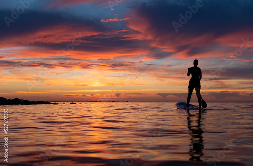 silhouette of a teenage girl on a Stand Up Paddle Board SUP.  colorful sunset sky reflecting in the water. Greifswalder Bodden, Baltic Sea © Martin Gruber