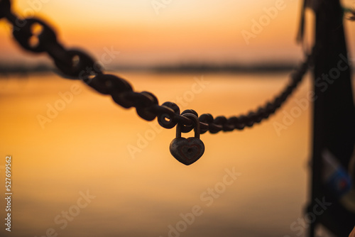 Chain with a heart lock on the sunset