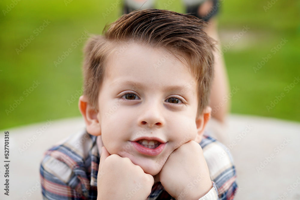 Niño feliz latino rubio posando para retrato disfrutando de un hermoso atardecer en el parque al aire libre jugando y siendo alegre y contento Niño feliz latino rubio posando para retrato disfrutando de un hermoso atardecer en el parque al aire libre jugando y siendo alegre y contento