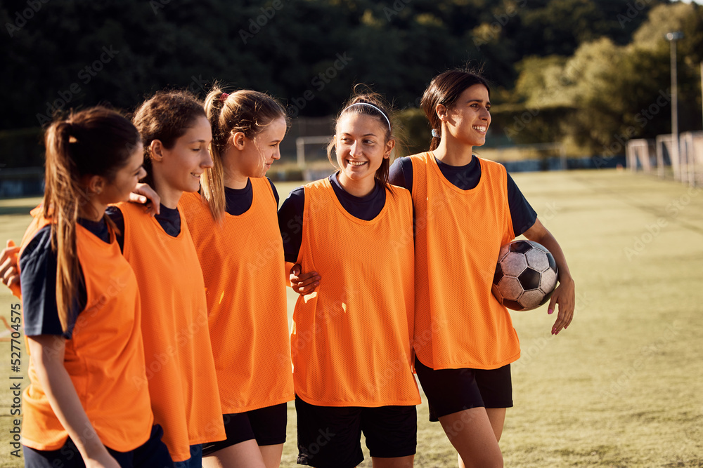Fototapeta premium Embraced female soccer players on playing field.