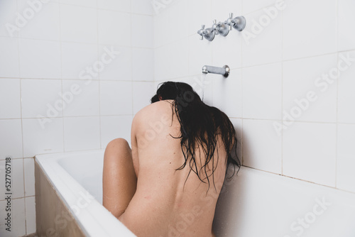young woman in bathtub, back pain, frustration, addiction and depression