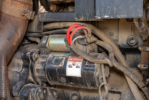 Engine starter on farm tractor. Agriculture and farming equipment repair, maintenance and service concept