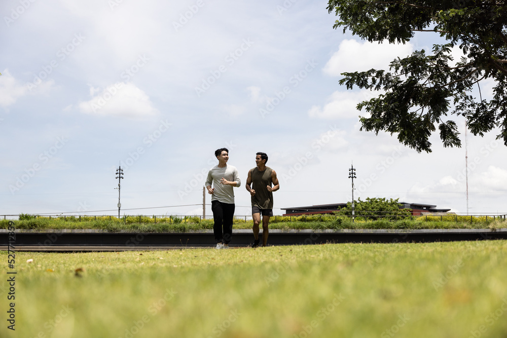 Asian young man jogging together in green park. Concept for healthy lifestyle and oudoor life. Asian young man jogging together in green park. Concept for healthy lifestyle and oudoor life.