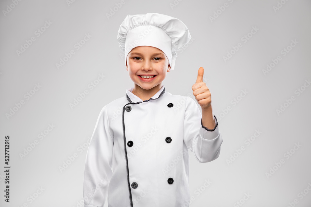 cooking, culinary and profession concept - happy smiling little boy in chef's toque and jacket showing thumbs up over grey background cooking, culinary and profession concept - happy smiling little boy in chef's toque and jacket showing thumbs up over grey background