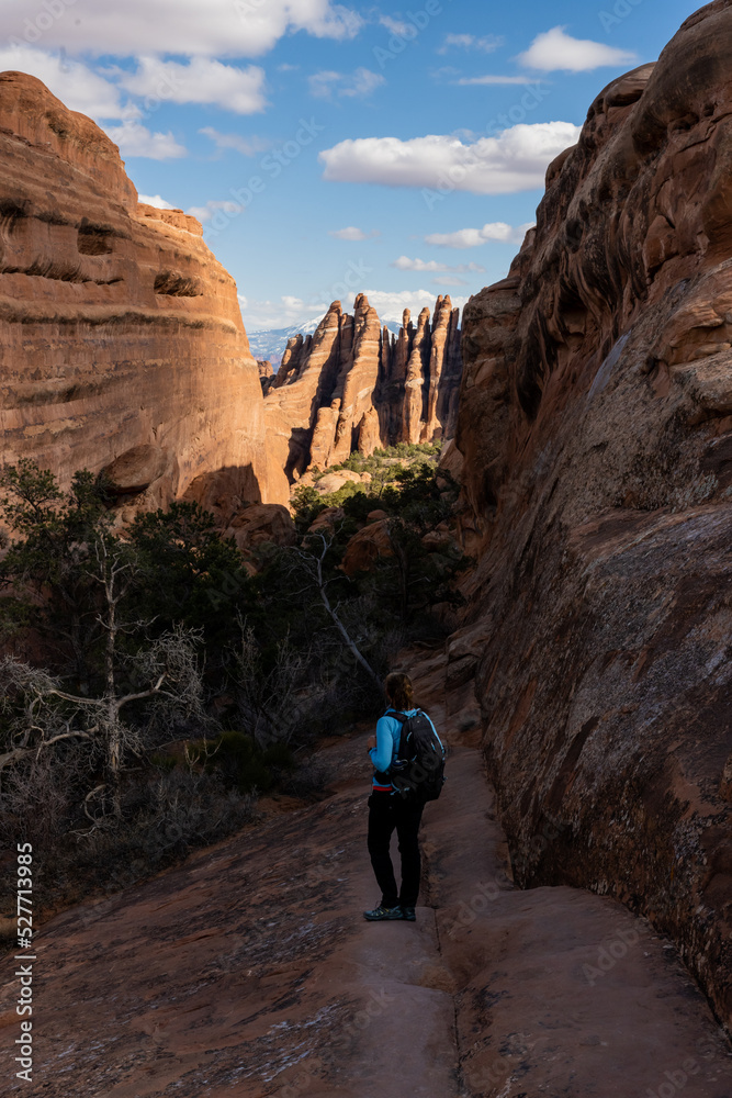 Hiker Heading Down a Slick Rock Trail Into a Canyon Hiker Heading Down a Slick Rock Trail Into a Canyon