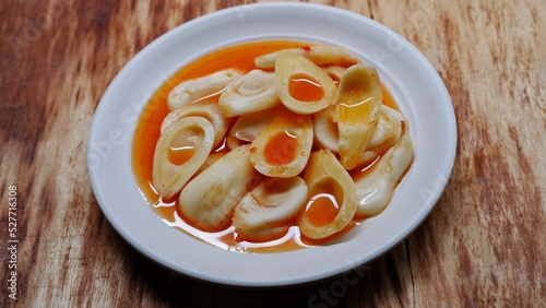 A plate of asinan Salak, Indonesian snake fruit spicy pickle on wooden background photo