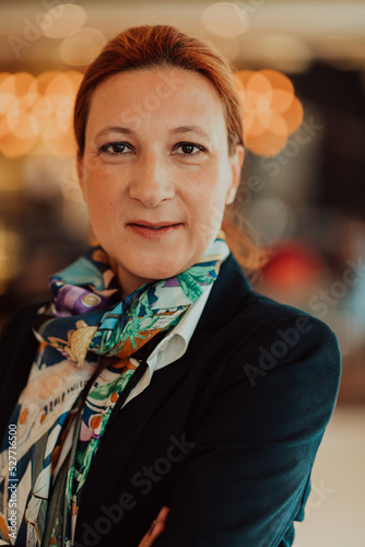 Portrait of business senior woman with crossed arms standing in modern corporation. Selective focus 