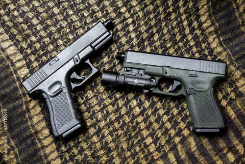 G19 gen4 and gen5 model,  Pistol weapon handheld polymer pistol and popular handgun weapon with flashlight attachment olive green color and black. photo