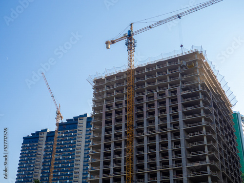 High-rise construction. Skyscraper under construction. Housing frame. Multi-apartment housing. Building cranes.  New area.