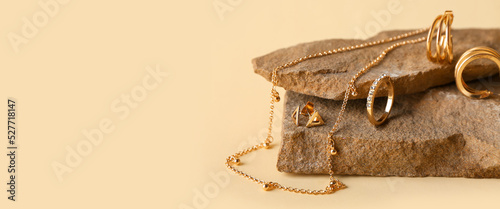 Granite stones and stylish jewelry on beige background with space for text, closeup
