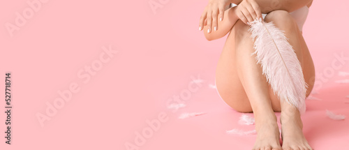 Beautiful young woman with soft feathers on pink background with space for text. Epilation concept photo