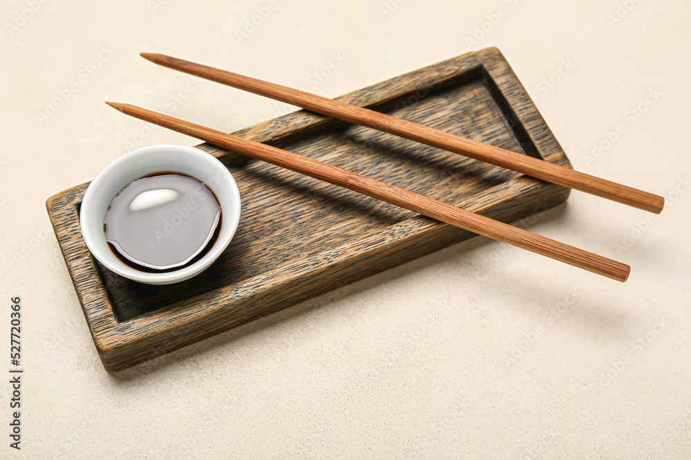 Bowl of soy sauce, chopsticks and wooden board on white background Bowl of soy sauce, chopsticks and wooden board on white background
