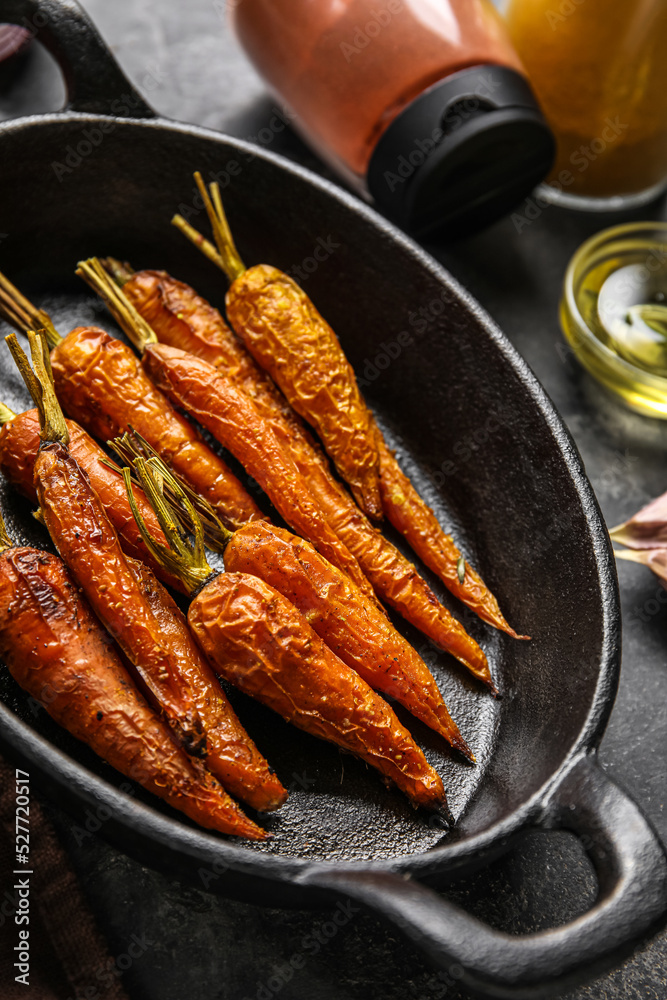 Baking dish with baked carrots on table, closeup Baking dish with baked carrots on table, closeup
