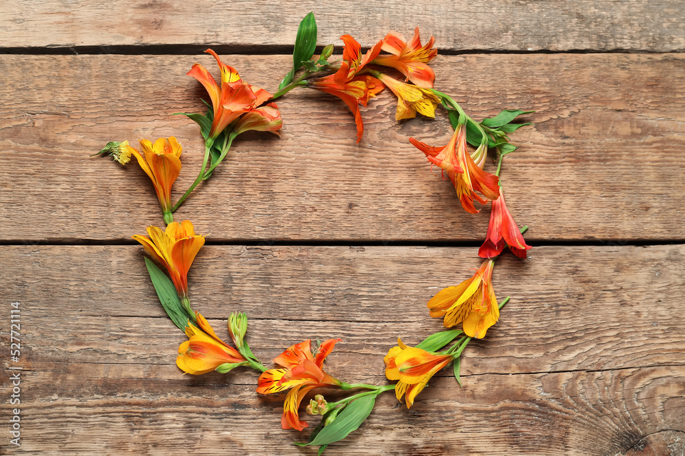 Frame made of beautiful alstroemeria flowers on wooden background