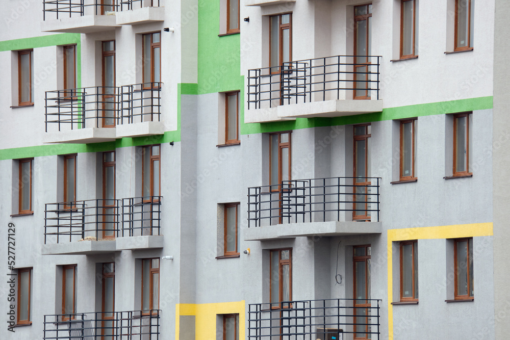 Architectural details of modern high apartment building facade with many windows and balconies Architectural details of modern high apartment building facade with many windows and balconies