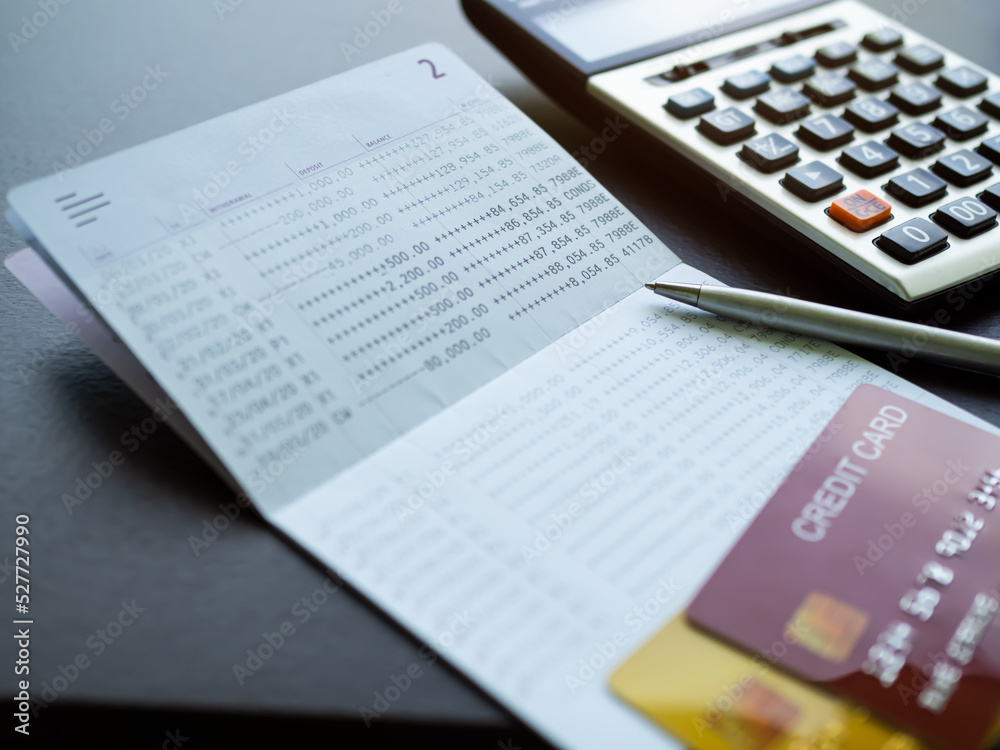 Obraz premium Credit Card on Book Bank with Pen and calculator table background,Technology Electronic Ecommerce Shopping Online,Plan Investment Income for 2023 New Year,Business and Finance concept.